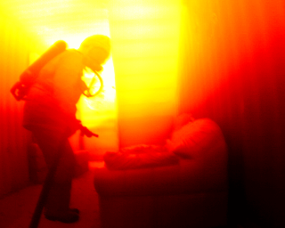 En rökdykare i en rökfylld övningsanläggning, ett exempel på vad en IR-kamera ser i ett brinnande hus