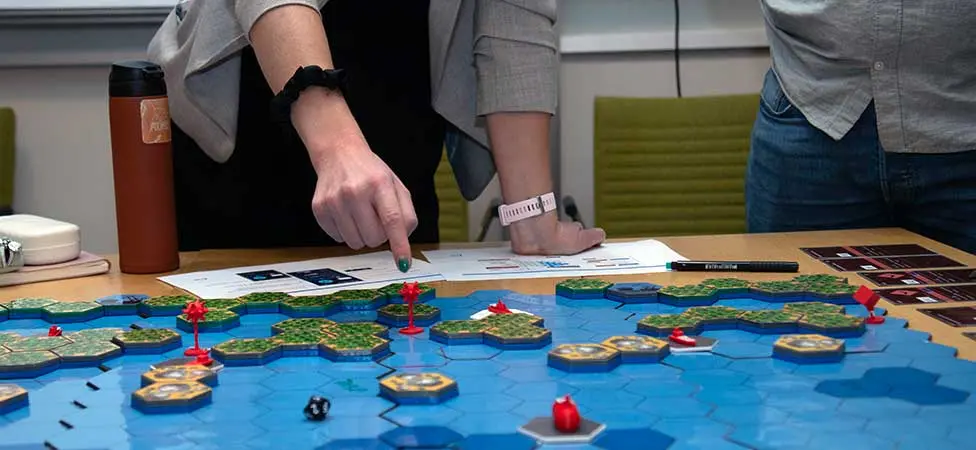 Personer som pekar på ett spelbräde.