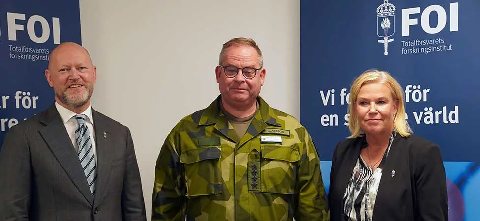 Två män och en kvinna på rad.