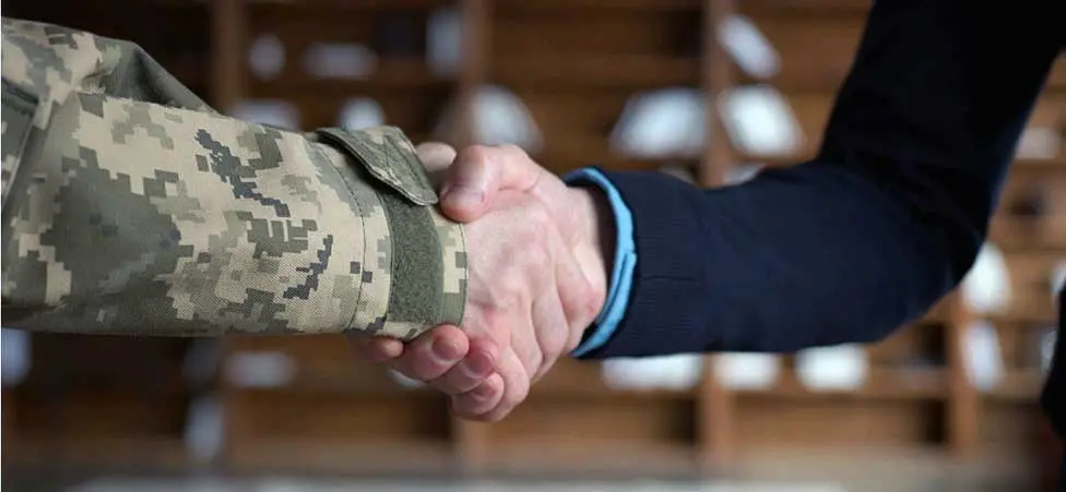 Ett handslag där den ene bär militär uniform.