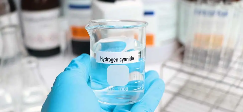 En hand som håller i ett kärl med vätecyanid.