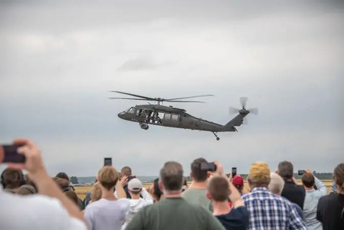 Åskadare tittar på och filmar en helikopter i luften